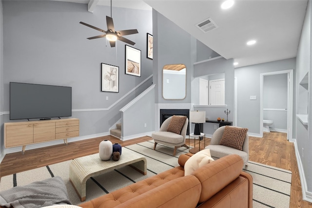 living room with beam ceiling, high vaulted ceiling, ceiling fan, and hardwood / wood-style floors