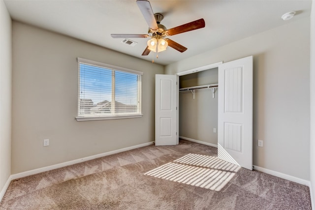 unfurnished bedroom featuring ceiling fan, light colored carpet, and a closet