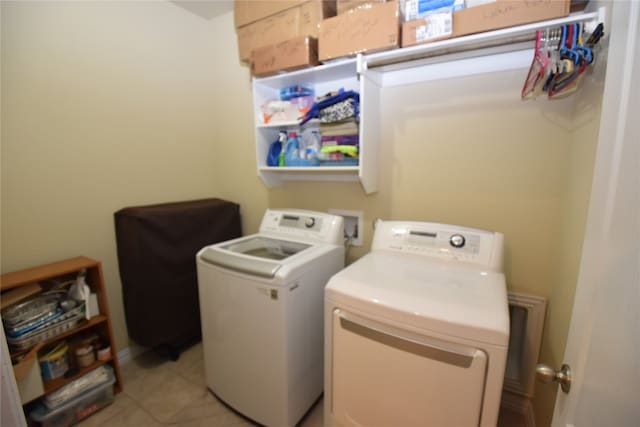 clothes washing area featuring light tile patterned floors and washing machine and clothes dryer