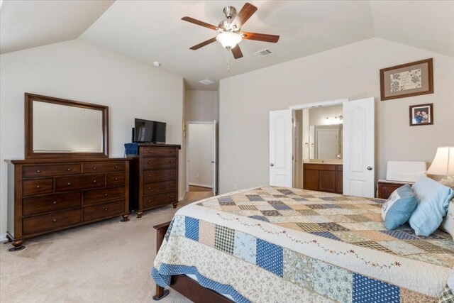 carpeted bedroom featuring ceiling fan, lofted ceiling, and ensuite bath