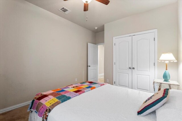 carpeted bedroom with ceiling fan and a closet