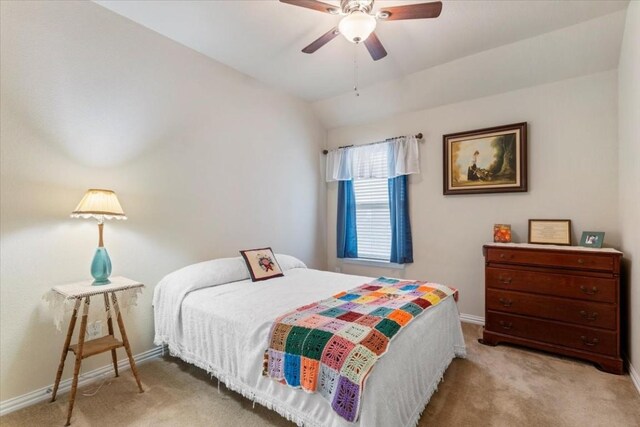 bedroom with ceiling fan, vaulted ceiling, and light carpet