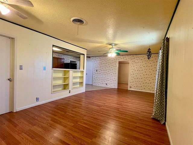 unfurnished room featuring ceiling fan, a textured ceiling, and wood-type flooring