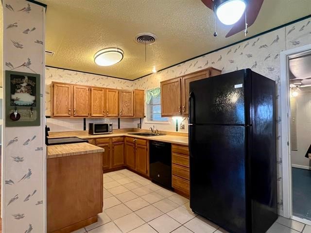 kitchen with ceiling fan, a textured ceiling, light tile floors, and black appliances