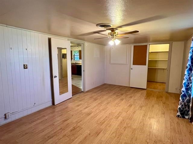 spare room with ceiling fan, light wood-type flooring, and french doors