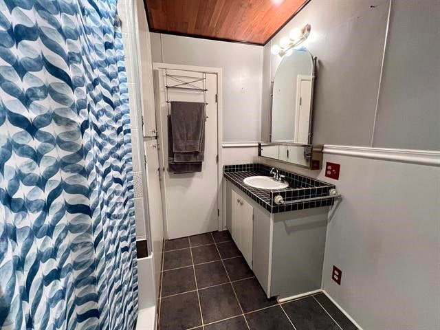 bathroom featuring wood ceiling, large vanity, and tile flooring