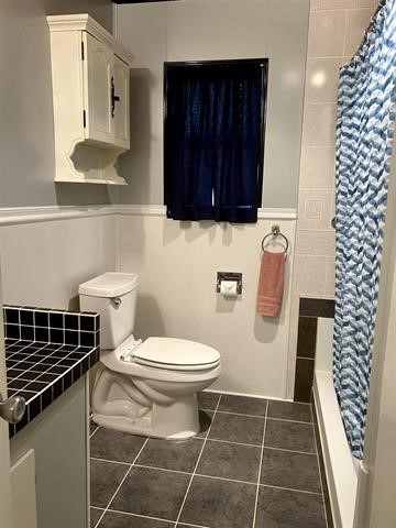 bathroom with toilet, vanity, and tile flooring