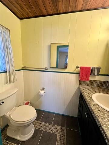 bathroom featuring vanity, tile floors, toilet, and wooden ceiling