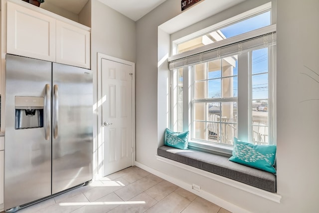 kitchen featuring white cabinets, stainless steel fridge with ice dispenser, and light tile patterned floors