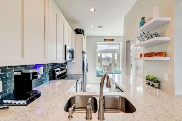 2918 Ranch Road 620 N Unit S-242, Austin, TX 78734 - kitchen with backsplash, appliances with stainless steel finishes, open shelves, light stone countertops, and a sink