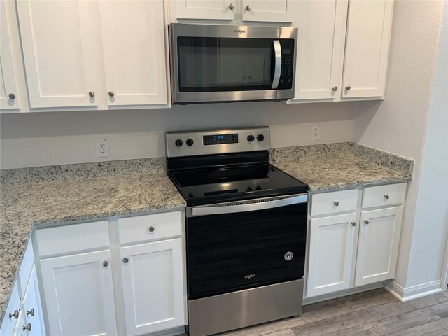 18624 Allen Welch Dr, Elgin, TX 78621 - kitchen with stainless steel appliances, white cabinetry, light wood-type flooring, and light stone countertops