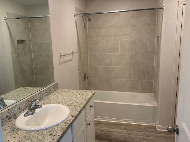 bathroom featuring tiled shower / bath combo, vanity, and wood-type flooring