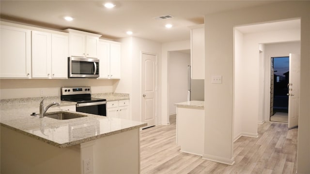 18624 Allen Welch Dr, Elgin, TX 78621 - kitchen with appliances with stainless steel finishes, light wood-style floors, white cabinets, and recessed lighting