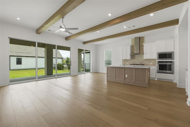 kitchen featuring appliances with stainless steel finishes, a wealth of natural light, wall chimney exhaust hood, and ceiling fan