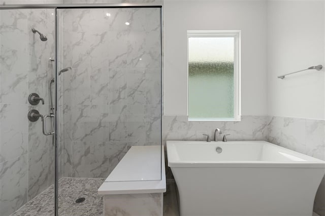 bathroom with plenty of natural light, independent shower and bath, and tile walls