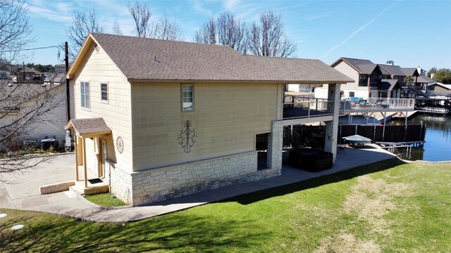 exterior space featuring a yard, a water view, and a balcony