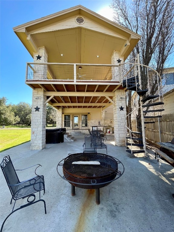 view of patio / terrace with a fire pit and a balcony