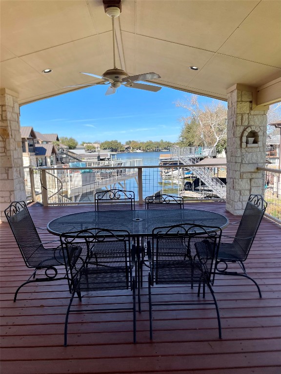 deck featuring ceiling fan and a water view