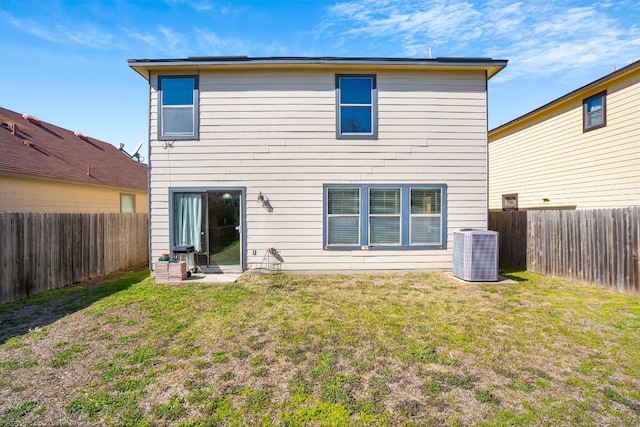 back of house featuring central air condition unit and a yard