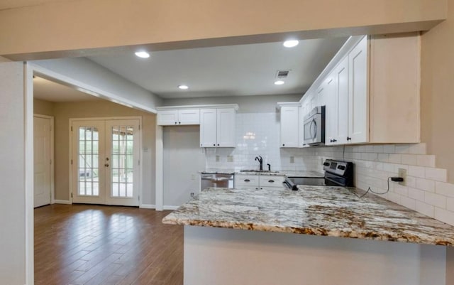 kitchen featuring french doors, dark hardwood / wood-style flooring, white cabinets, appliances with stainless steel finishes, and light stone countertops