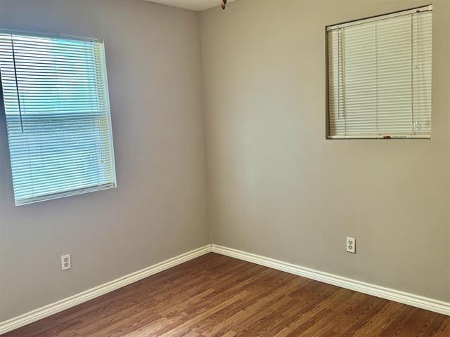 unfurnished room with wood-type flooring and a healthy amount of sunlight