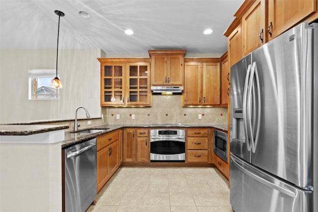 kitchen with sink, light tile patterned floors, hanging light fixtures, stainless steel appliances, and dark stone counters