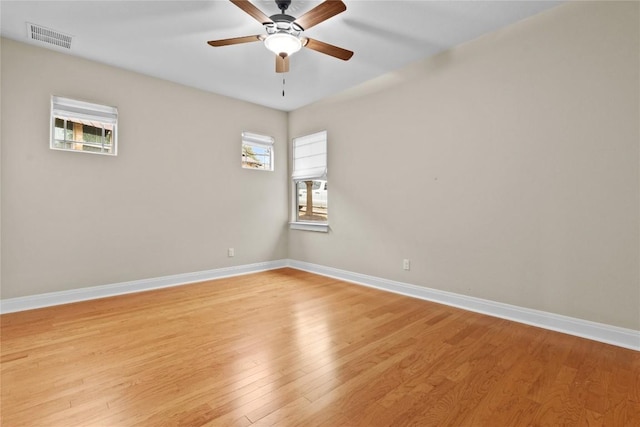 spare room featuring ceiling fan, light hardwood / wood-style floors, and a healthy amount of sunlight