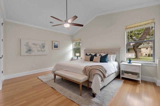 bedroom featuring ceiling fan, ornamental molding, lofted ceiling, and light hardwood / wood-style flooring