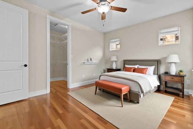 bedroom featuring hardwood / wood-style flooring, a spacious closet, ceiling fan, and a closet