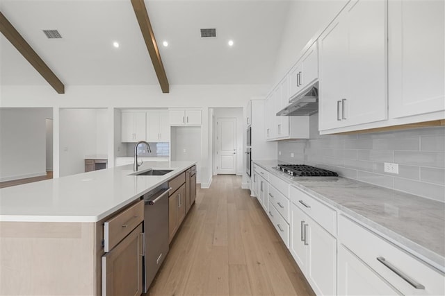 kitchen featuring light wood-type flooring, a large island, sink, white cabinets, and beamed ceiling