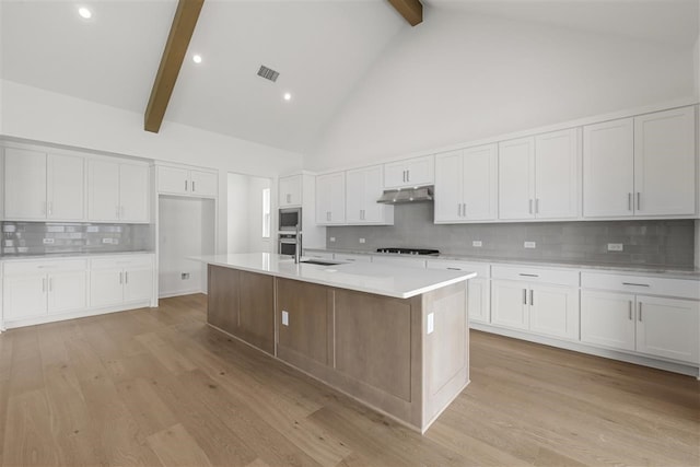 kitchen featuring beamed ceiling, backsplash, high vaulted ceiling, and light hardwood / wood-style flooring