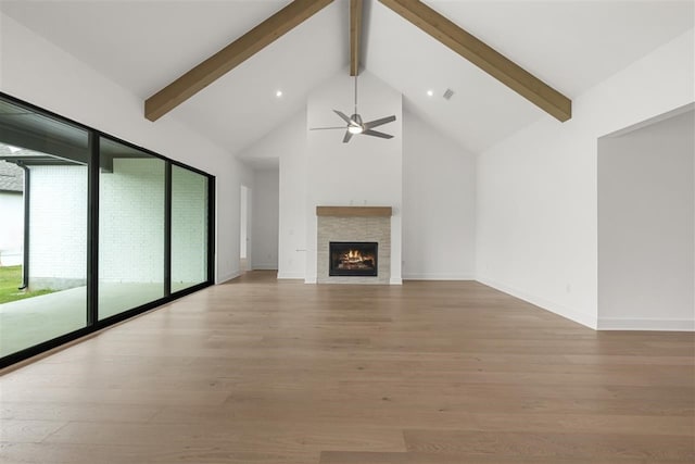 unfurnished living room featuring high vaulted ceiling, beamed ceiling, ceiling fan, and light hardwood / wood-style flooring