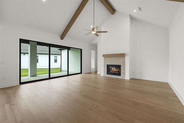 unfurnished living room featuring ceiling fan, hardwood / wood-style flooring, beamed ceiling, and high vaulted ceiling