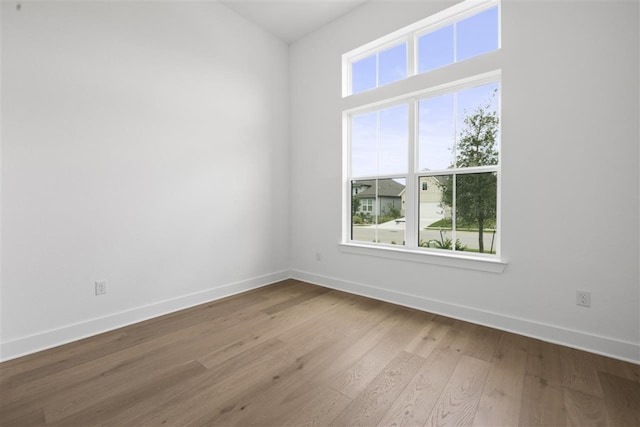 unfurnished room featuring plenty of natural light and hardwood / wood-style flooring