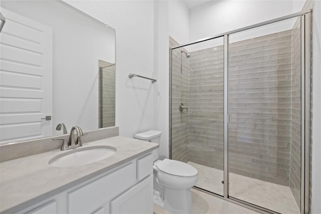 bathroom featuring vanity, toilet, and a shower with door