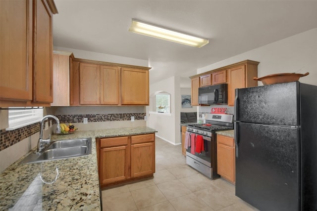 kitchen with sink, light tile patterned flooring, black appliances, and backsplash