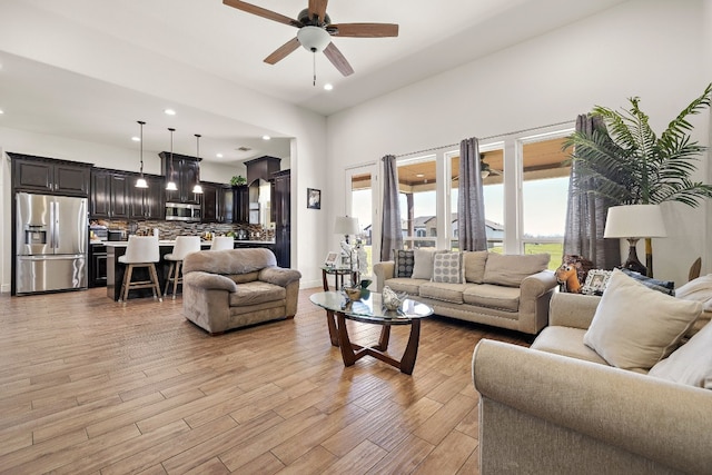 living room with light hardwood / wood-style floors and ceiling fan