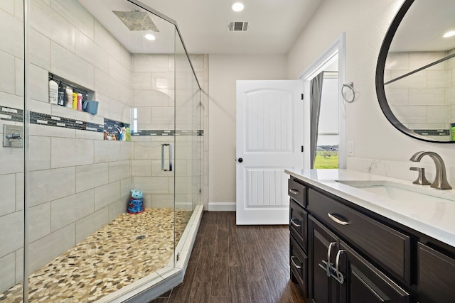 bathroom featuring a shower with shower door, vanity, and wood-type flooring