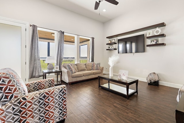 living room featuring ceiling fan and dark hardwood / wood-style flooring