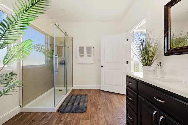 bathroom featuring vanity, a shower with shower door, and wood-type flooring