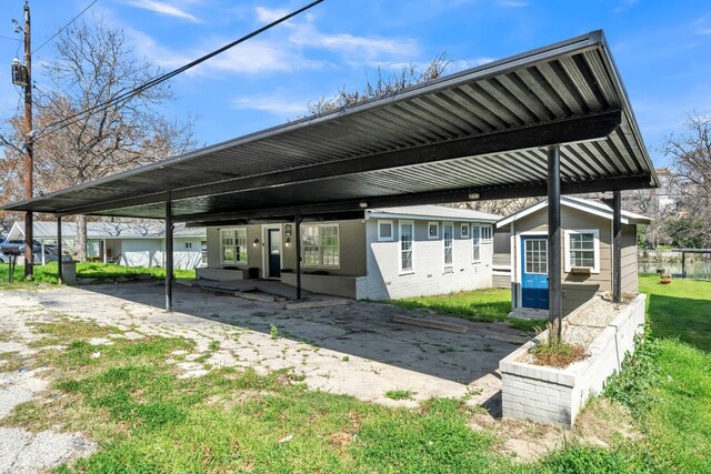 exterior space featuring a carport and a lawn