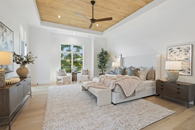 bedroom featuring a raised ceiling, light hardwood / wood-style flooring, ceiling fan, and wood ceiling