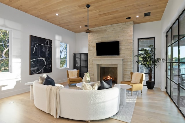 living room with plenty of natural light, light hardwood / wood-style floors, and wooden ceiling