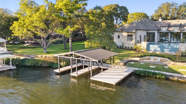 view of dock with a yard and a water view