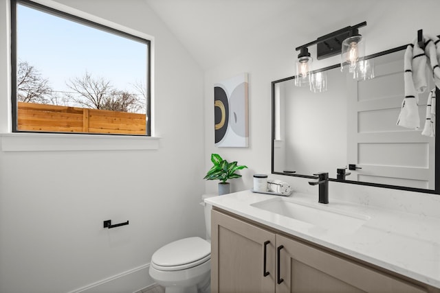 bathroom featuring vanity, vaulted ceiling, and toilet