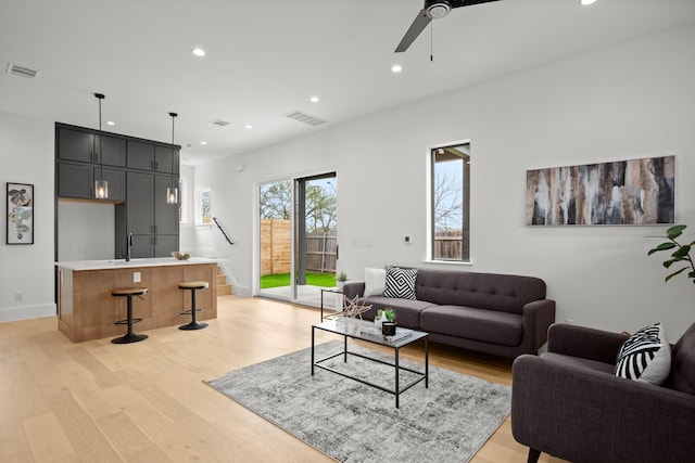 living room with ceiling fan and light hardwood / wood-style floors