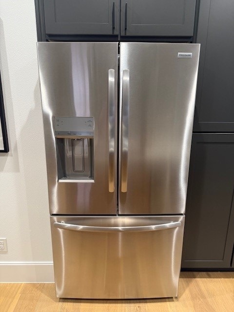 details featuring stainless steel fridge and light hardwood / wood-style floors