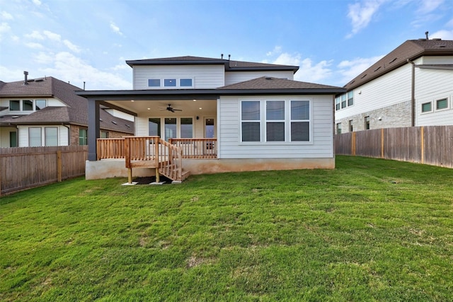 back of house with ceiling fan and a yard