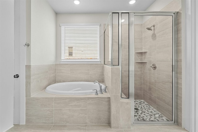 bathroom with tile patterned flooring and shower with separate bathtub