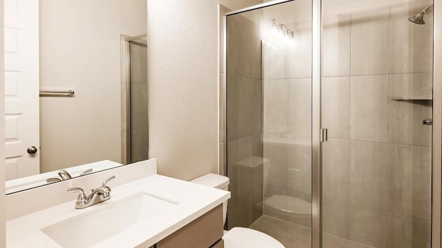 bathroom featuring vanity, toilet, and a shower with shower door